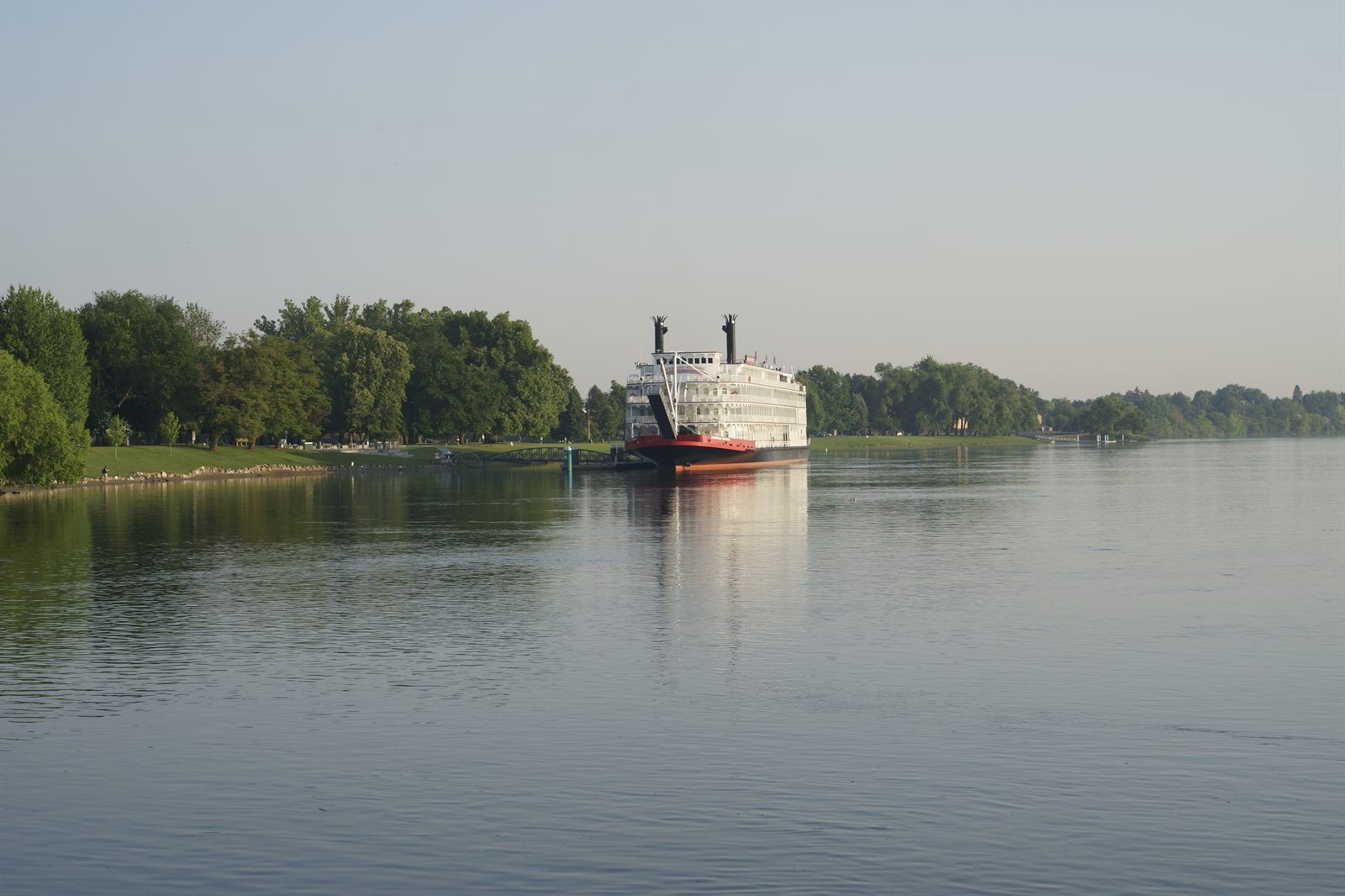 Riverboat on a wide, calm river in soft morning light